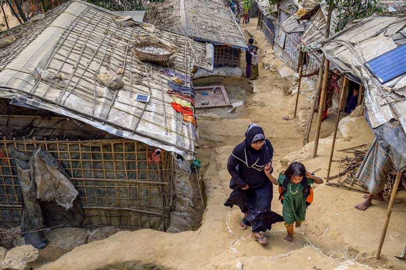 A mother and her daughter walk through the Rohingya refugee camp in Cox's Bazar.