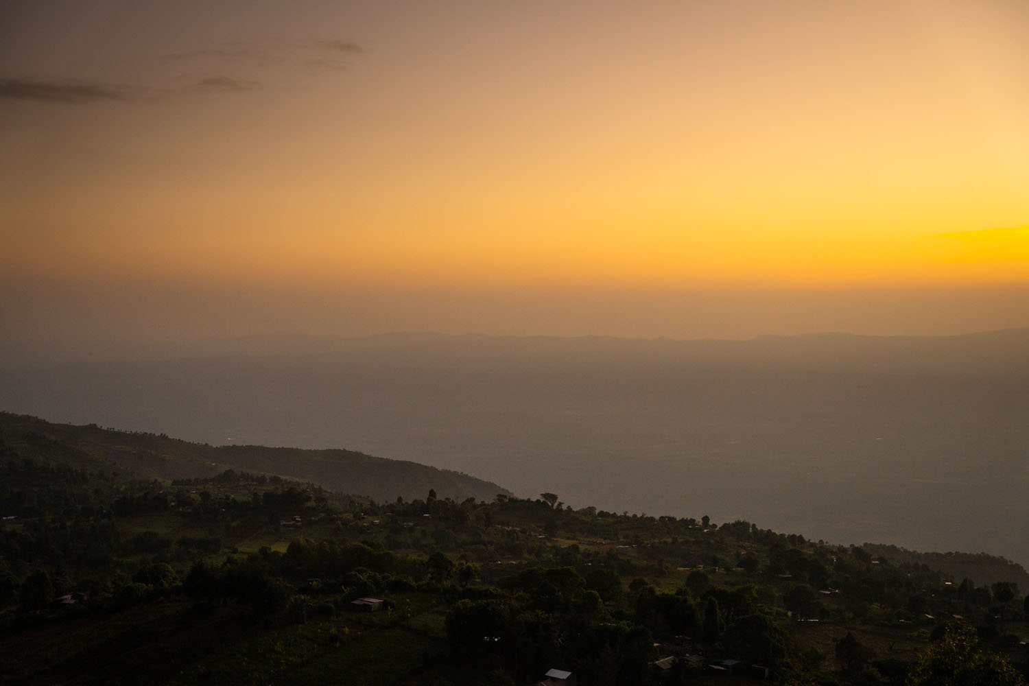 The sun rises over the green hills of Rift Valley in Kenya. 