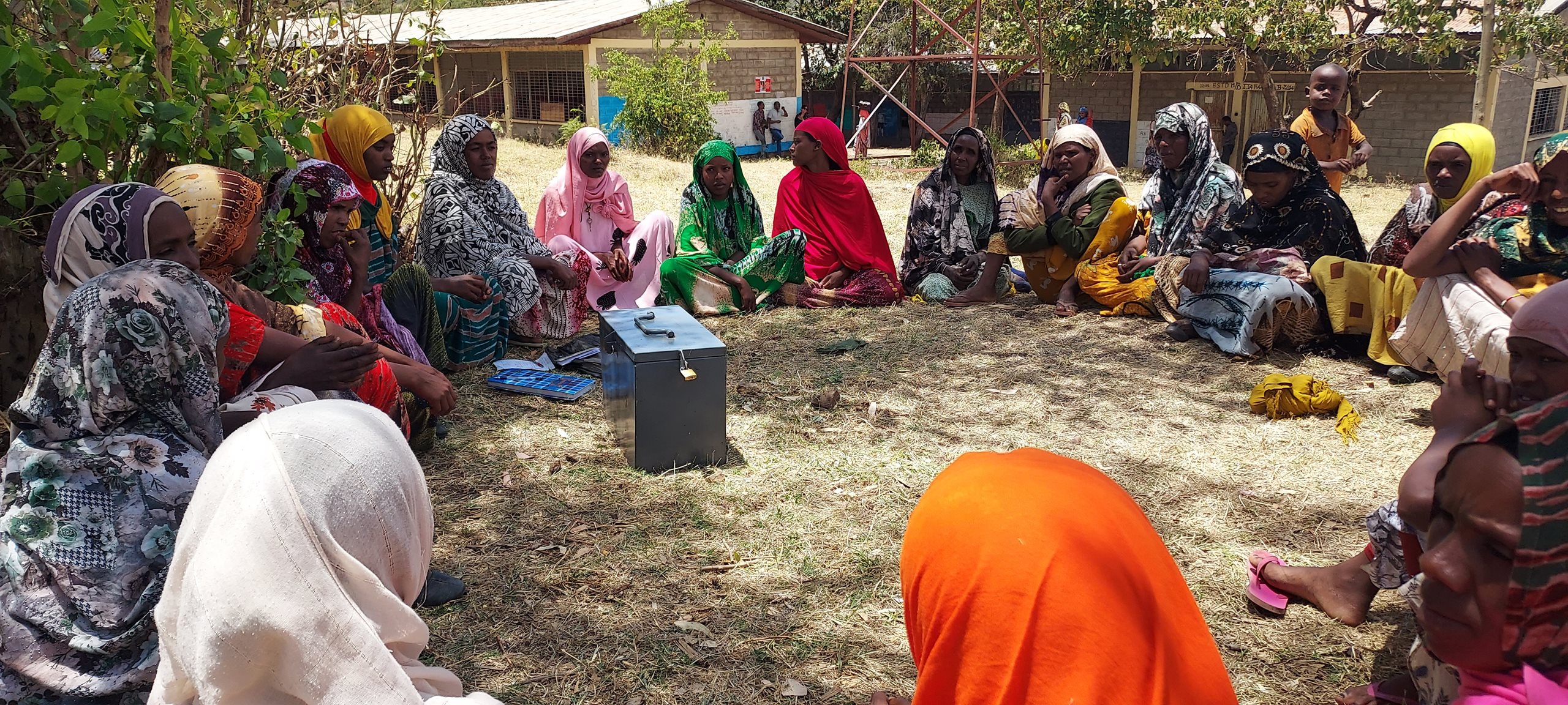 Saving groups members sit in a circle.