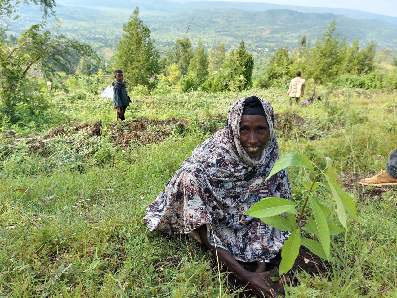 A woman smiles while working the ground.