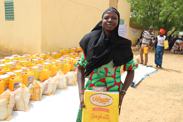 a woman carries a box of food supplies