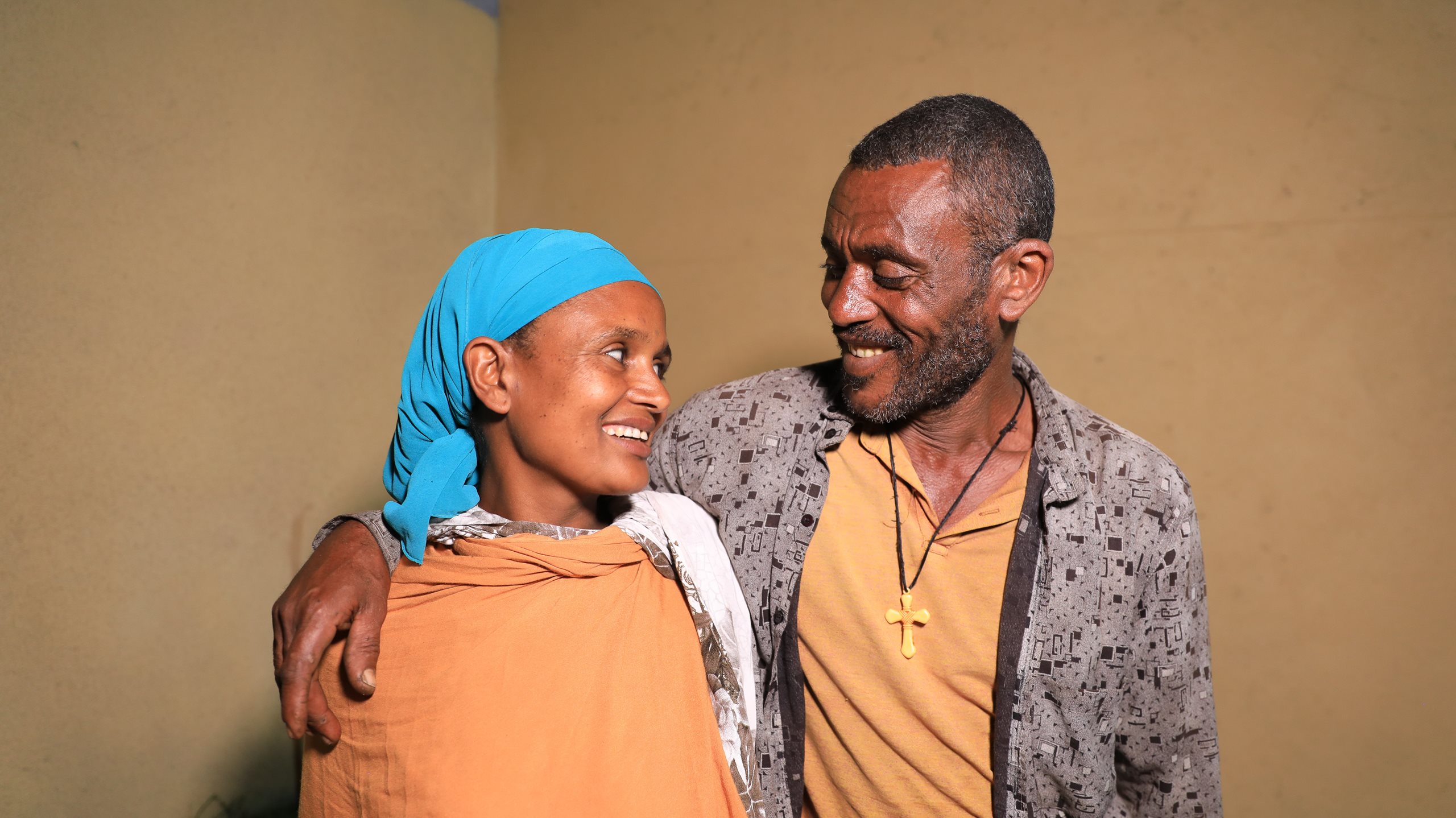 A woman and a man smile at one another. 