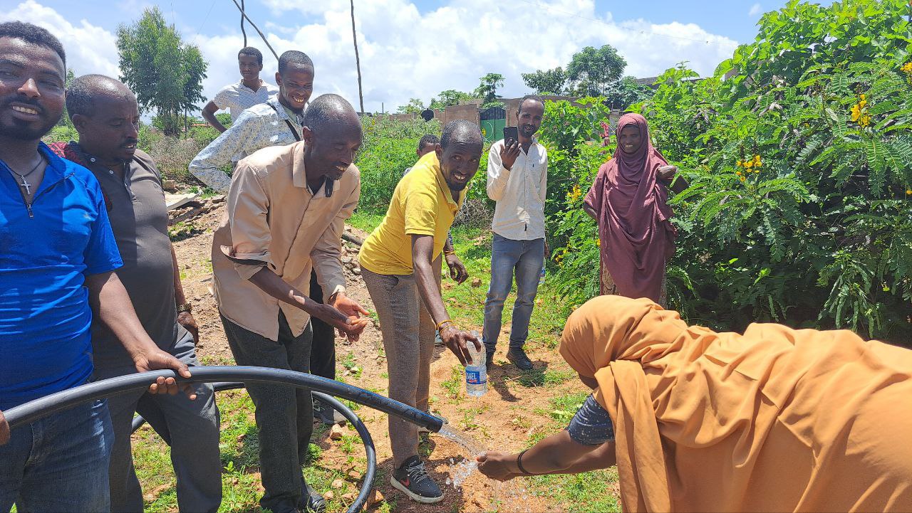 Communities enjoying the results of a functioning pump - clean water!