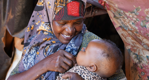 A woman holds her baby. 